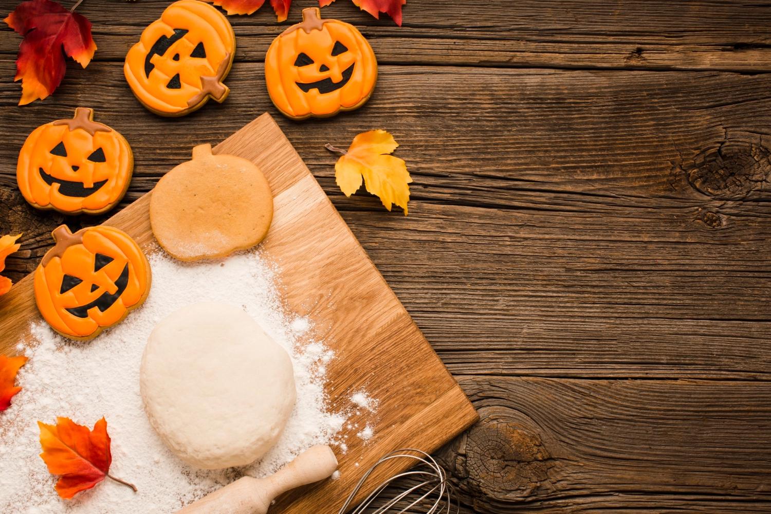 Pumpkin-shaped cookies surrounded by autumn leaves, illustrating cozy baking moments and fall date ideas.