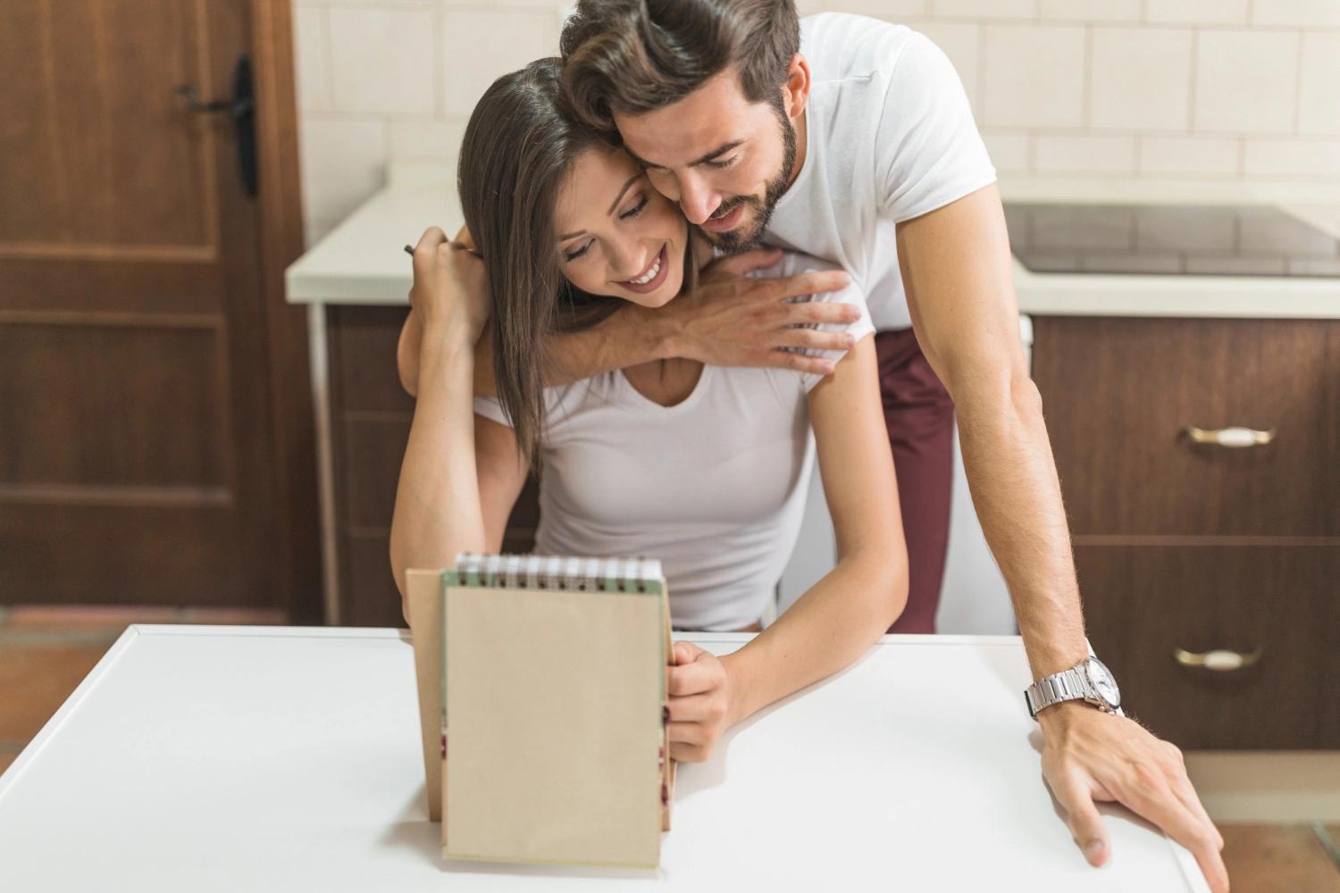 A couple embracing and leaning over a list of goals they set together, which represents goals setting for couples, an essential element in good communication and a healthy relationshp.