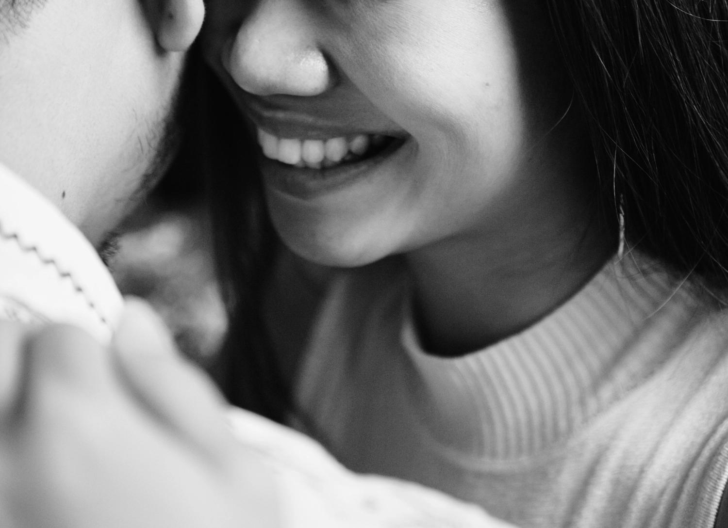 A black and white photo of a couple laughing and hugging as they ask each other funny questions for couples.