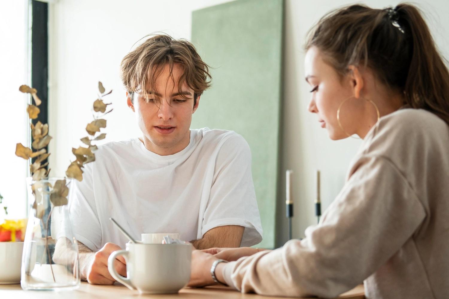 A man and a woman standing at a table and asking each other questions for couples about the future and dreams.