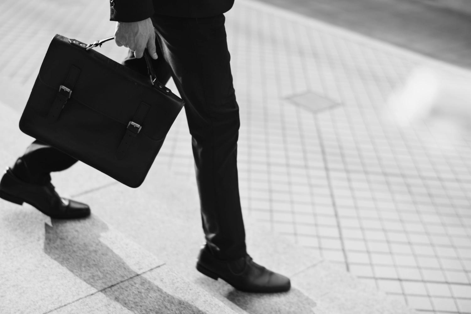 A business man carring a briefcase, going to wrk, which represents reflective questons for couples about career or school.
