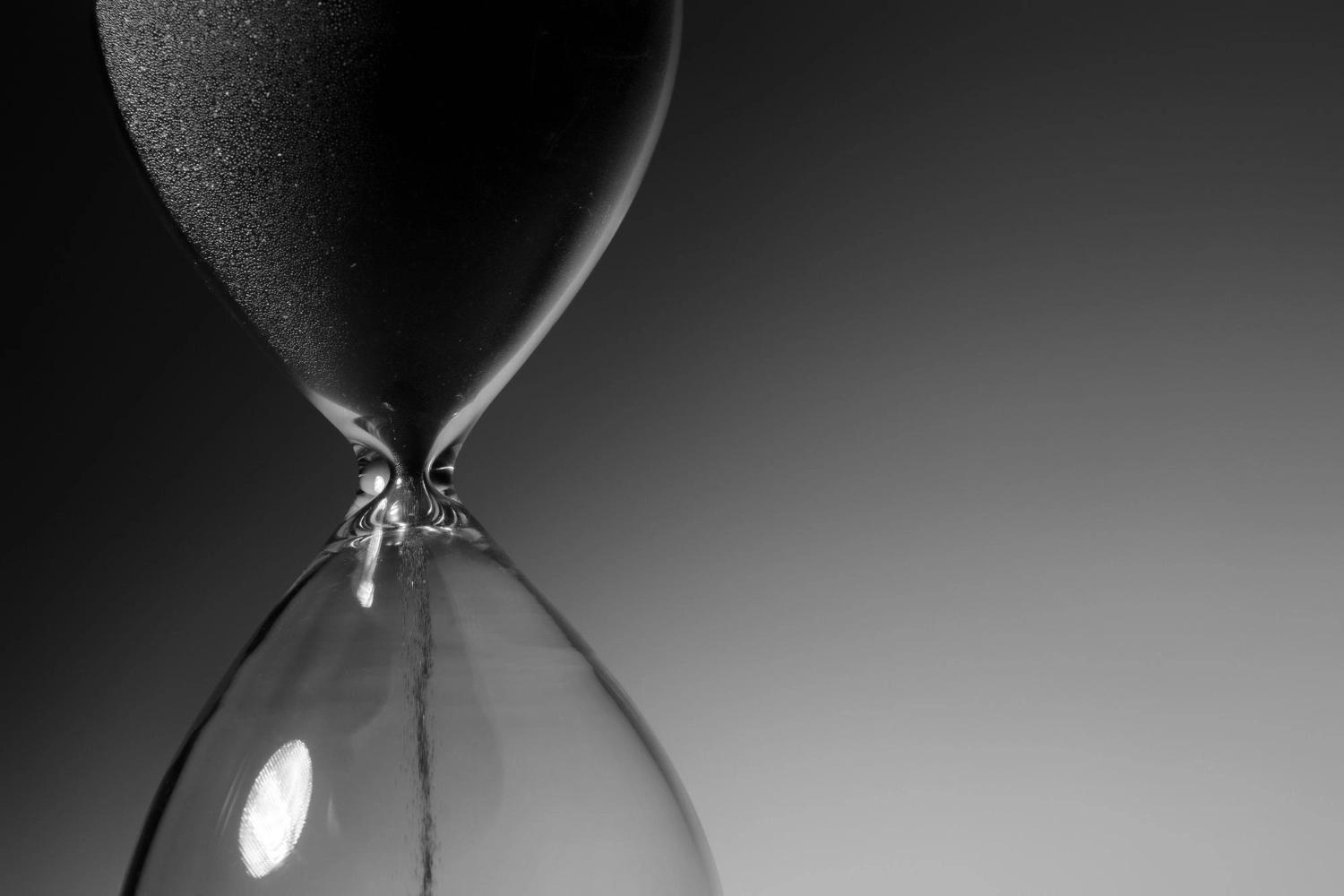 A black-and-white photo of an hourglass, representing the passing of time and the importance of reflective questions for couples to connect.