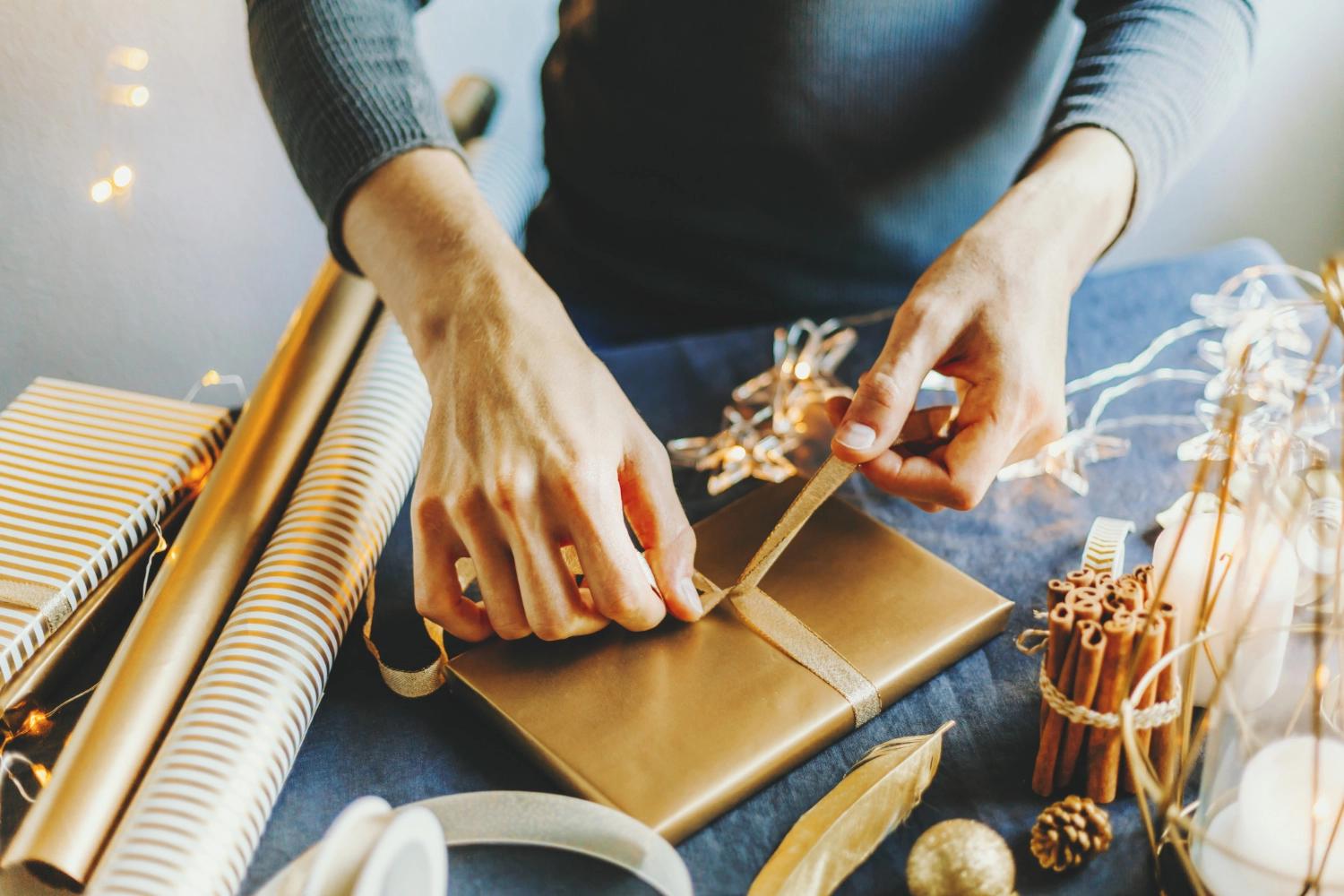 A man wrapping gifts, which is an essential part of the National Make a Gift Day, one of the most important relationship holidays.