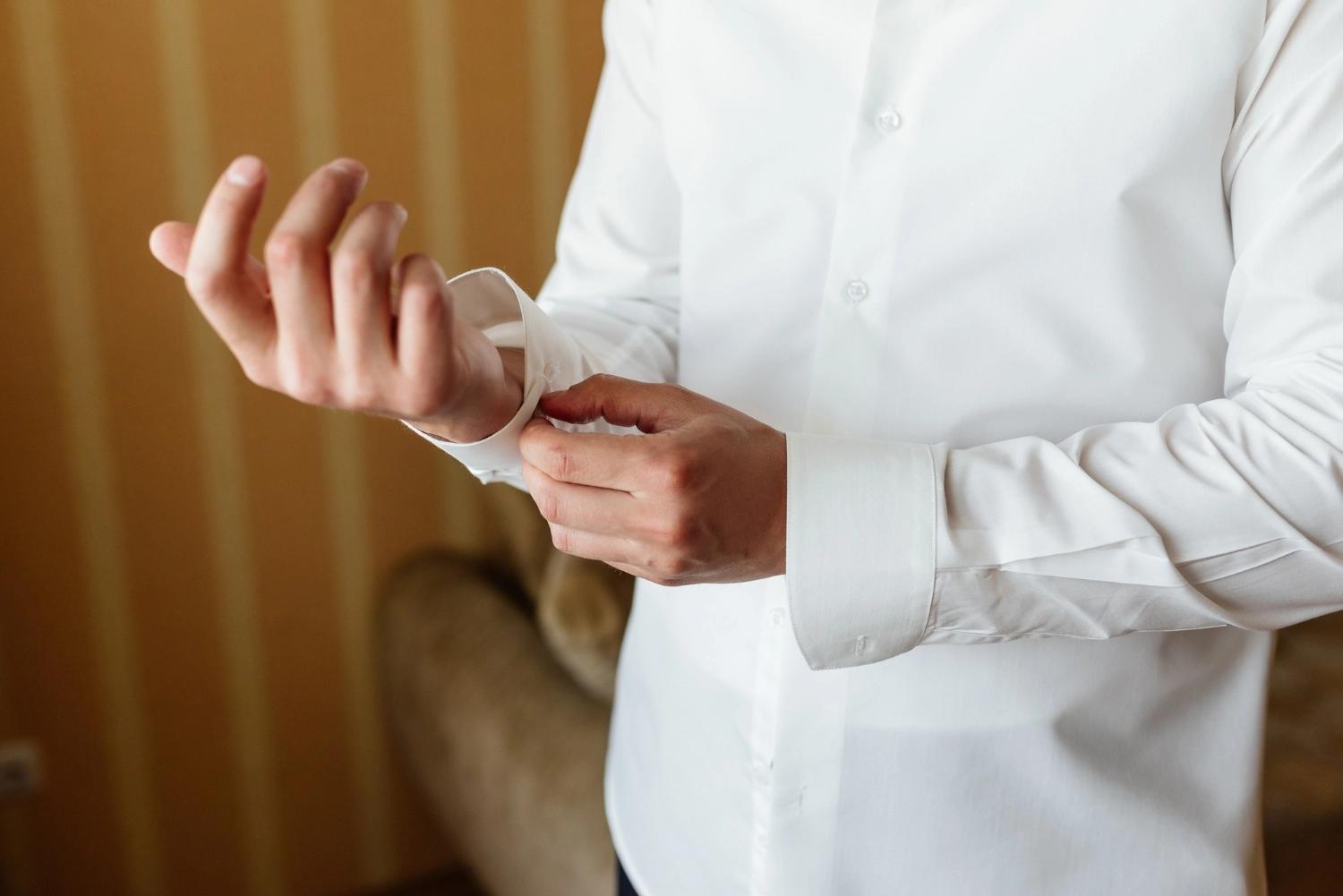 A man rolling up his button-down shirt’s sleeves, which is considered one of the major turn ons.