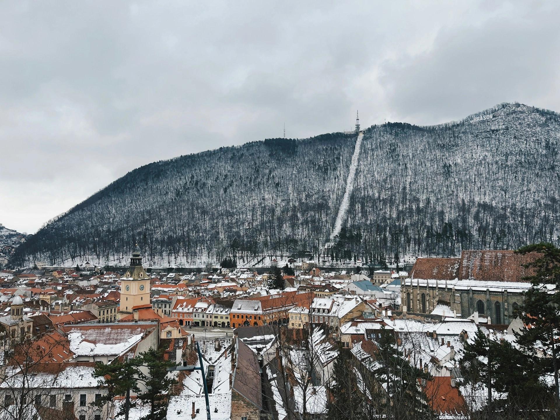 A paronamic view from above of snowy Brasov, Romania, which is one of the best winter weekend getaways for couples.