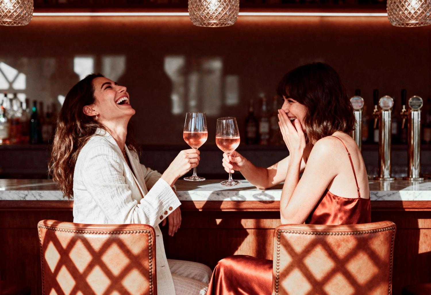 A couple having a glass of wine at a fancy restaurant, which is one of the best Valentine's Day date ideas.
